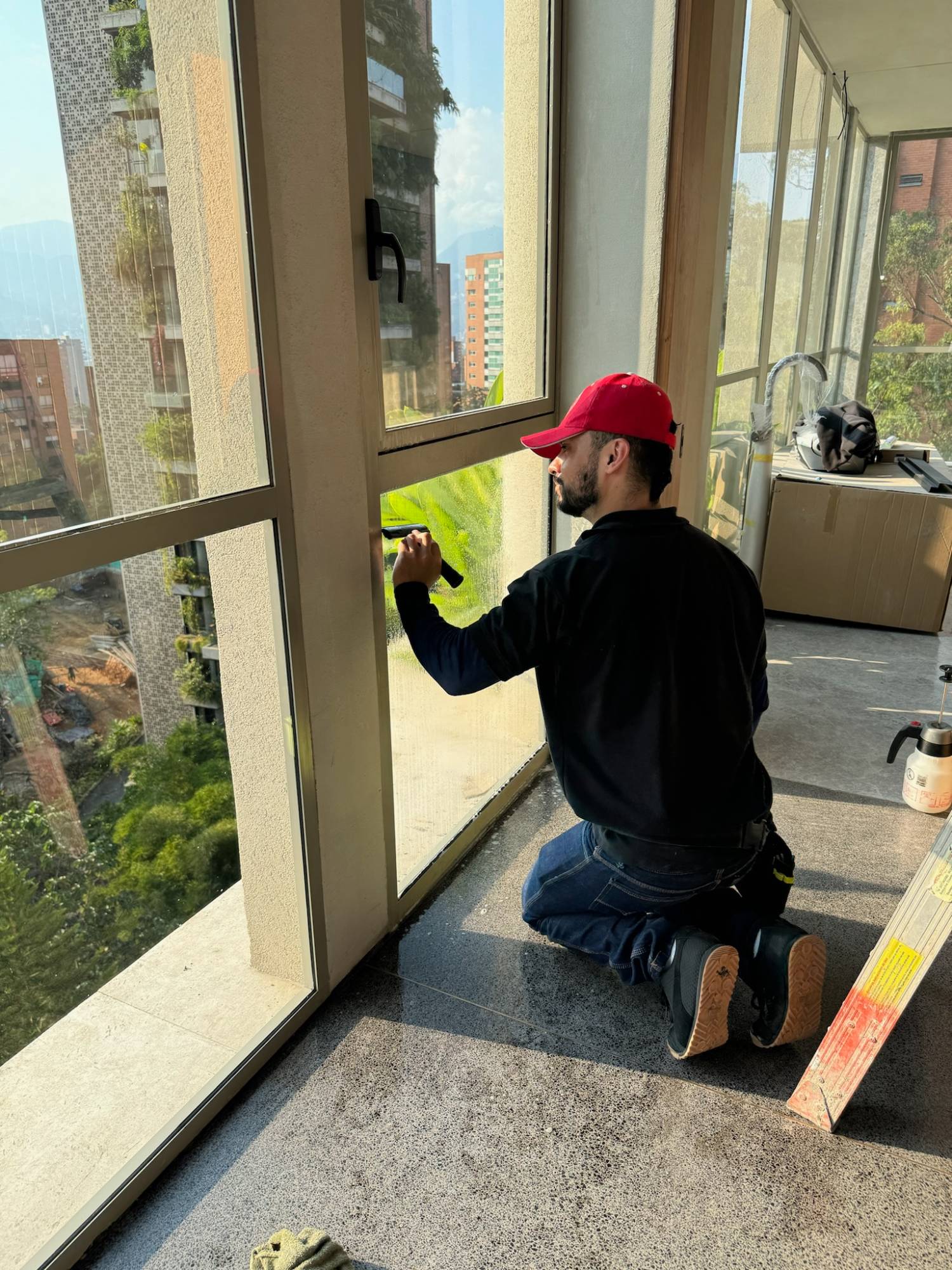 Instalador aplicando película de control solar a una ventana