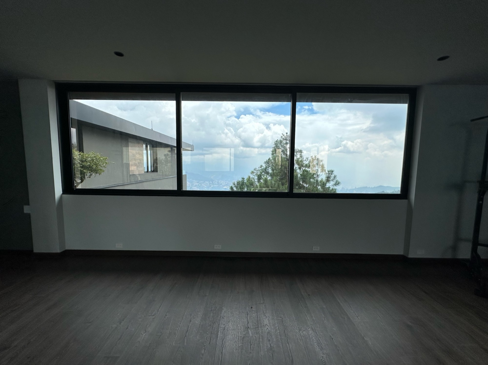 Sala con ventanal y película de control solar hacia las montañas